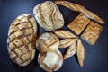 Various French breads, such as baguette, petits pains and loafs of sourdough, called pain de campagne, on display on a table.