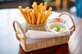 breadsticks in a napkin-lined basket with dips on the side Royalty Free Stock Photo