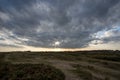 A break in the clouds. Bleak landscape with distant sun breaking