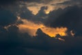 Break in the clouds. Sun emerging behind dark storm clouds Royalty Free Stock Photo