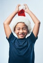 Break out your hats and bring on the Christmas cheer. Studio shot of a cute little boy wearing a Santa hat against a Royalty Free Stock Photo