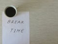 Break Time Concept. Relaxation. Office desk table with break time note and coffee cup. Top view.