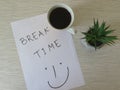 Worktable. Break Time Concept. Office desk table with break time note, coffee cup and flowers. Relaxation. Top view. Royalty Free Stock Photo