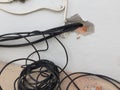 Break in the wall with protruding electrical wires, Electric wire sticking out of a white wall, crack hole wall