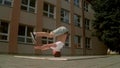 Breakdancer spins on his head on the street, slowmotion