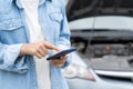 breakdown, broken car, repair. Woman uses mobile phone check insurance premiums through application due to car accident . Find