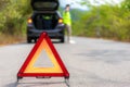 Breakdown triangle sign on road with worried Asian man talking by mobile phone with insurance or car service center company after