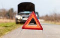 Breakdown triangle stands on a broken car