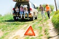 A breakdown triangle stands near a broken car - of road