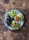 Breakfast, appetizer or snack plate - salmon, avocado, arugula bruschetta, grapes, kiwi. Healthy food concept. On wooden backgroun