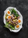 Breakfast, appetizers, snack plate - boiled eggs, potatoes, string beans, red onion, cucumber, canned tuna salad on a dark Royalty Free Stock Photo