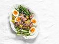 Breakfast, appetizers, snack plate - boiled eggs, potatoes, string beans, red onion, cucumber, canned tuna salad on a light