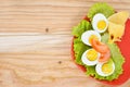 Breakfast background. Hard boiled eggs, sliced in halves, salad, tomatoes and cheese on the red plate. Royalty Free Stock Photo