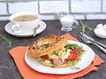 Breakfast, bagel with scramble egg, ham, arugula and vegetables on a white plate Royalty Free Stock Photo