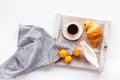 Breakfast in bed with croissant, coffee in cup with milk on tray on white background top view Royalty Free Stock Photo