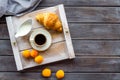 Breakfast in bed with croissant, coffee in cup with milk on tray on wooden background top view Royalty Free Stock Photo