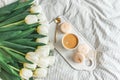 Breakfast in bed, cup of cappuccino, flowers