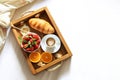 Breakfast in bed tray with cup of coffee, fresh french croissant and fruits on white sheet top view, copy space. Honeymoon. Mornin Royalty Free Stock Photo