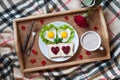 Breakfast in bed with heart-shaped eggs, toasts, jam, coffee, rose and petals. Valentines Day surprise. Royalty Free Stock Photo