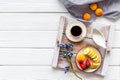 Breakfast in bed with strawberry, apricot, banana, coffee in cup with milk on white wooden background top view