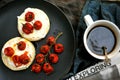 Breakfast in bed with toasted tomatoes on crumpets and newspaper