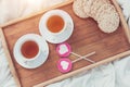 Breakfast in bed in Valentines day. Cup of tea and sweet candies. Love or holiday concept Royalty Free Stock Photo