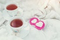 Breakfast in bed in Valentines day. Cup of tea and sweet candies. Love or holiday concept Royalty Free Stock Photo