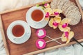 Breakfast in bed in Valentines day. Cup of tea and sweet candies. Love or holiday concept Royalty Free Stock Photo