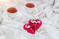 Breakfast in bed in Valentines day. Cup of tea and sweet candies. Love or holiday concept Royalty Free Stock Photo