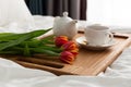 Breakfast in bed on a wooden table tray. light from the window. Flowers Royalty Free Stock Photo