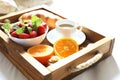 Breakfast in bed, a wooden tray of coffee, croissants, strawberry, orange close up. Honeymoon. Morning at the hotel.