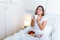 Breakfast in bed for young beautiful woman. Woman having coffee and breakfast in bed with fruits, coffee and biscuits. Morning Royalty Free Stock Photo