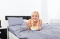 Breakfast in bed, young woman lying on bed Royalty Free Stock Photo