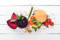 Breakfast. Beetroot juice and avocado burger and vegetables. On a wooden background.