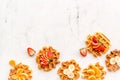 Breakfast with Belgian waffles with strawberry, tangerine and banana topings on white marble background top view mockup