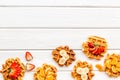 Breakfast with Belgian waffles with strawberry, tangerine and banana topings on white wooden background top view mockup