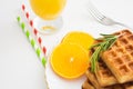 Breakfast with belgium waffles with rosemary and orange slices. Closeup view Royalty Free Stock Photo