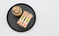 Breakfast in the black of round plate on the white floor. Strawberry and kiwi fruit with cream Sandwich, a glass of ice coffee Royalty Free Stock Photo