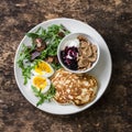 Breakfast - boiled egg, arugula, cherry tomatoes salad, greek yogurt with whole grain cereal, blueberries berry sauce, pancakes