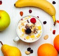 Breakfast with bowl of milk, cereals and red fruits on white table and fresh fruit Royalty Free Stock Photo