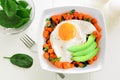 Breakfast bowl with sweet potato, egg, avocado and spinach over white wood Royalty Free Stock Photo