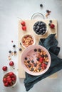Breakfast bowl with yogurt, blueberries, cherries and flakes on a grey table