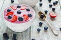 Breakfast bowl with yogurt, muesli, fresh blueberries and strawberries. Light wooden background Royalty Free Stock Photo