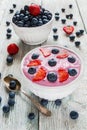 Breakfast bowl with yogurt, muesli, fresh blueberries and strawberries. Light wooden background Royalty Free Stock Photo