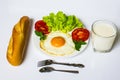 Breakfast with bread, fried eggs, milk and vegetables and fried tomato pieces isolated on white background. Royalty Free Stock Photo