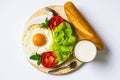 Breakfast with bread, fried eggs, milk and vegetables and fried tomato pieces isolated on white background. Royalty Free Stock Photo