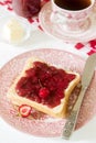 Breakfast of bread toasts with butter and strawberry-rhubarb jam, served with tea. Rustic style. Royalty Free Stock Photo