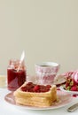 Breakfast of bread toasts with butter and strawberry-rhubarb jam, served with tea. Rustic style. Royalty Free Stock Photo