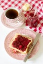 Breakfast of bread toasts with butter and strawberry-rhubarb jam, served with tea. Rustic style. Royalty Free Stock Photo