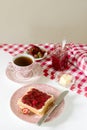 Breakfast of bread toasts with butter and strawberry-rhubarb jam, served with tea. Rustic style. Royalty Free Stock Photo